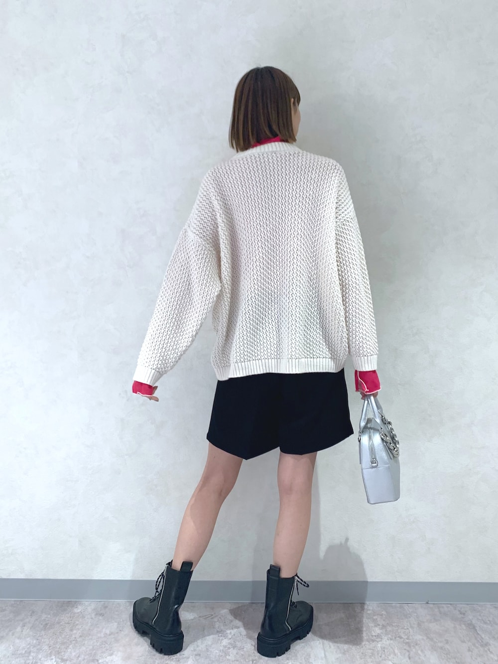 ホワイト系のニット/セーター、ブラック系のその他パンツ、ブラック系のブーツを着用したレディースの冬コーディネートの3枚目の写真