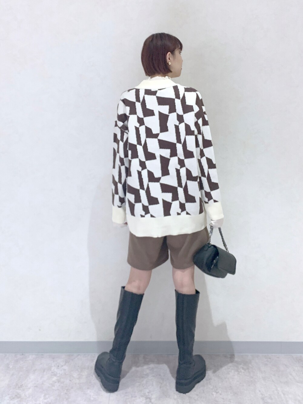 ブラック系のブーツ、ブラウン系のその他パンツ、ブラウン系のカーディガン/ボレロを着用したレディースの秋コーディネートの4枚目の写真