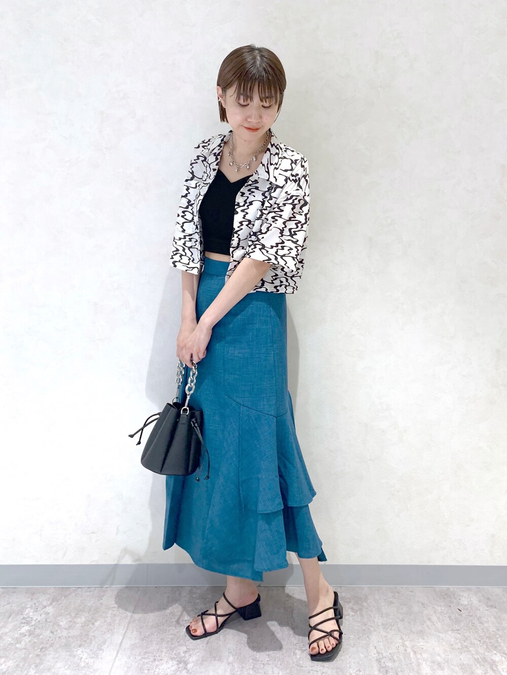 ブラック系のサンダル、ブルー系のスカート、ブラック系のタンクトップを着用したレディースの夏コーディネートの2枚目の写真