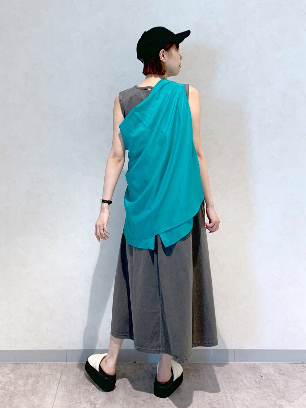 グレー系のワンピース、ホワイト系のサンダル、グリーン系のシャツ/ブラウスを着用したレディースの春コーディネートの4枚目の写真