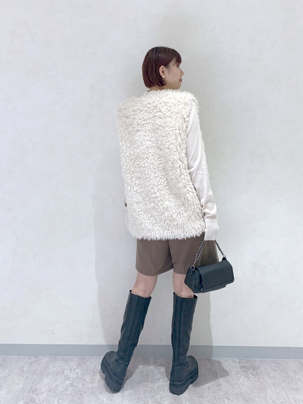 ブラック系のショルダーバッグ、ブラック系のブーツ、ブラウン系のその他パンツを着用したレディースの秋コーディネートの4枚目の写真