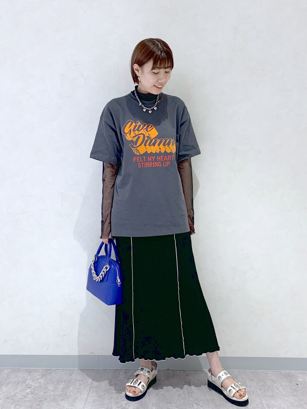 ブルー系のショルダーバッグ、ホワイト系のサンダル、ブラック系のスカートを着用したレディースの春コーディネートの4枚目の写真