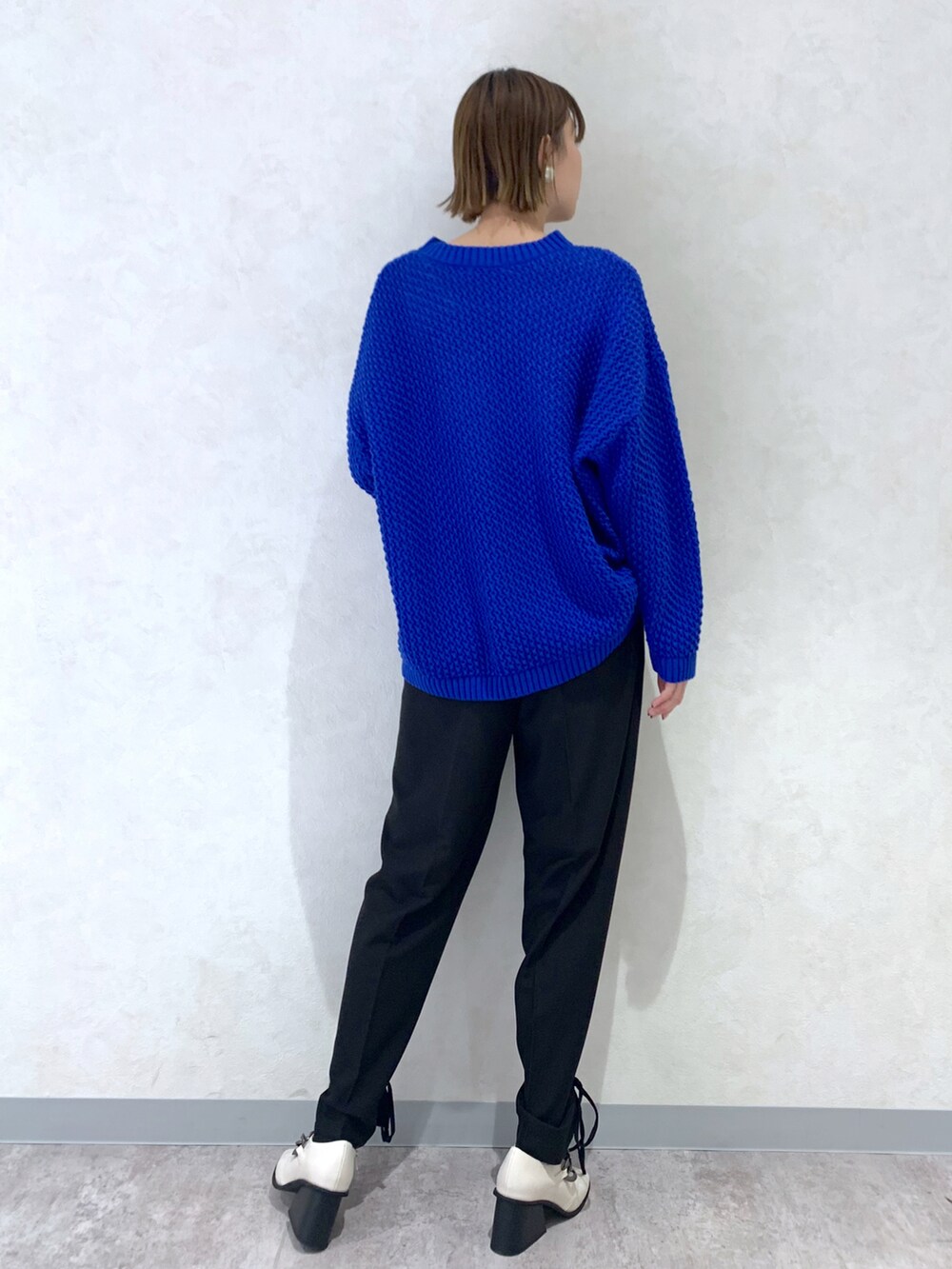 ブルー系のニット/セーター、ブラック系のその他パンツ、ホワイト系のパンプスを着用したレディースの冬コーディネートの4枚目の写真