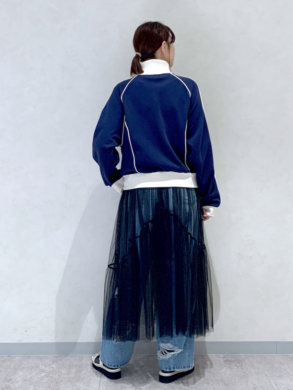 ブルー系のセットアップ、ブルー系のデニムパンツ、ブラック系のワンピースを着用したレディースの春コーディネートの4枚目の写真