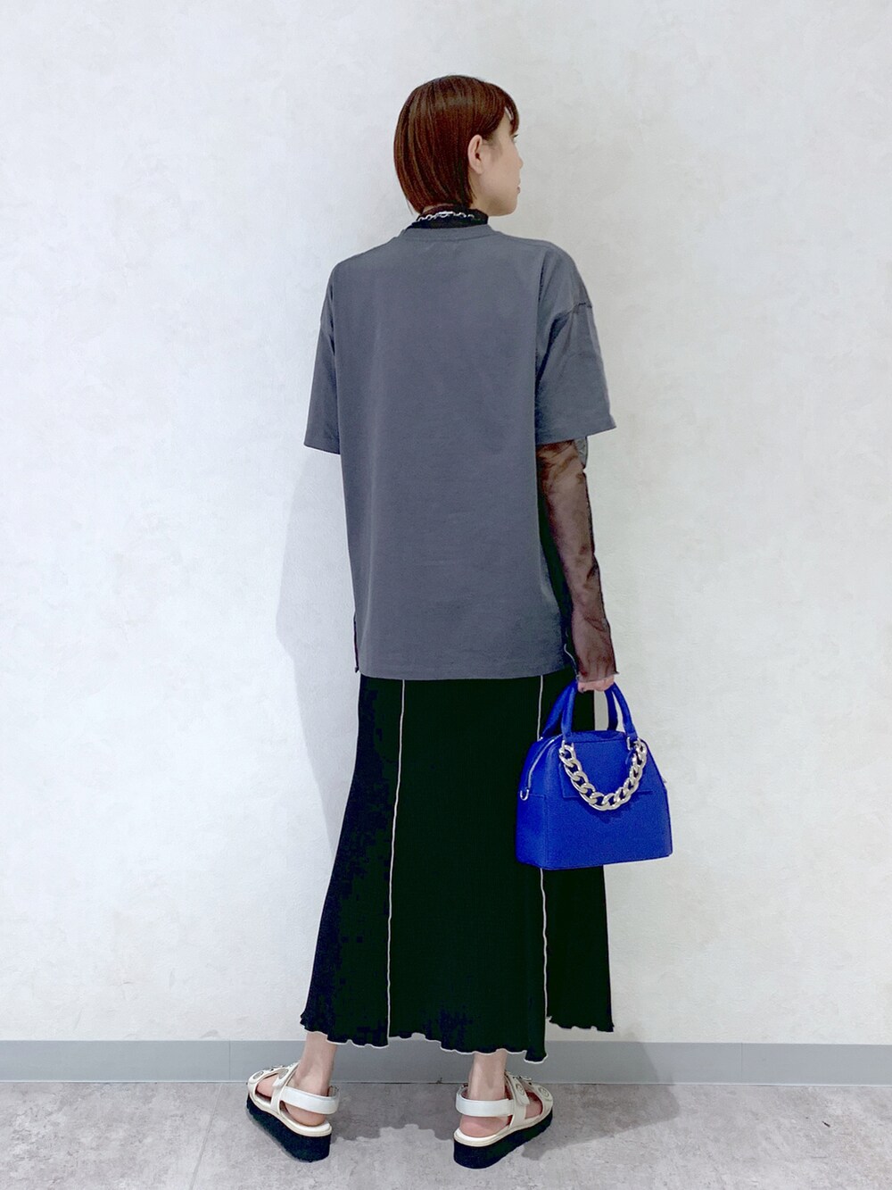 ブルー系のショルダーバッグ、ホワイト系のサンダル、ブラック系のスカートを着用したレディースの春コーディネートの3枚目の写真