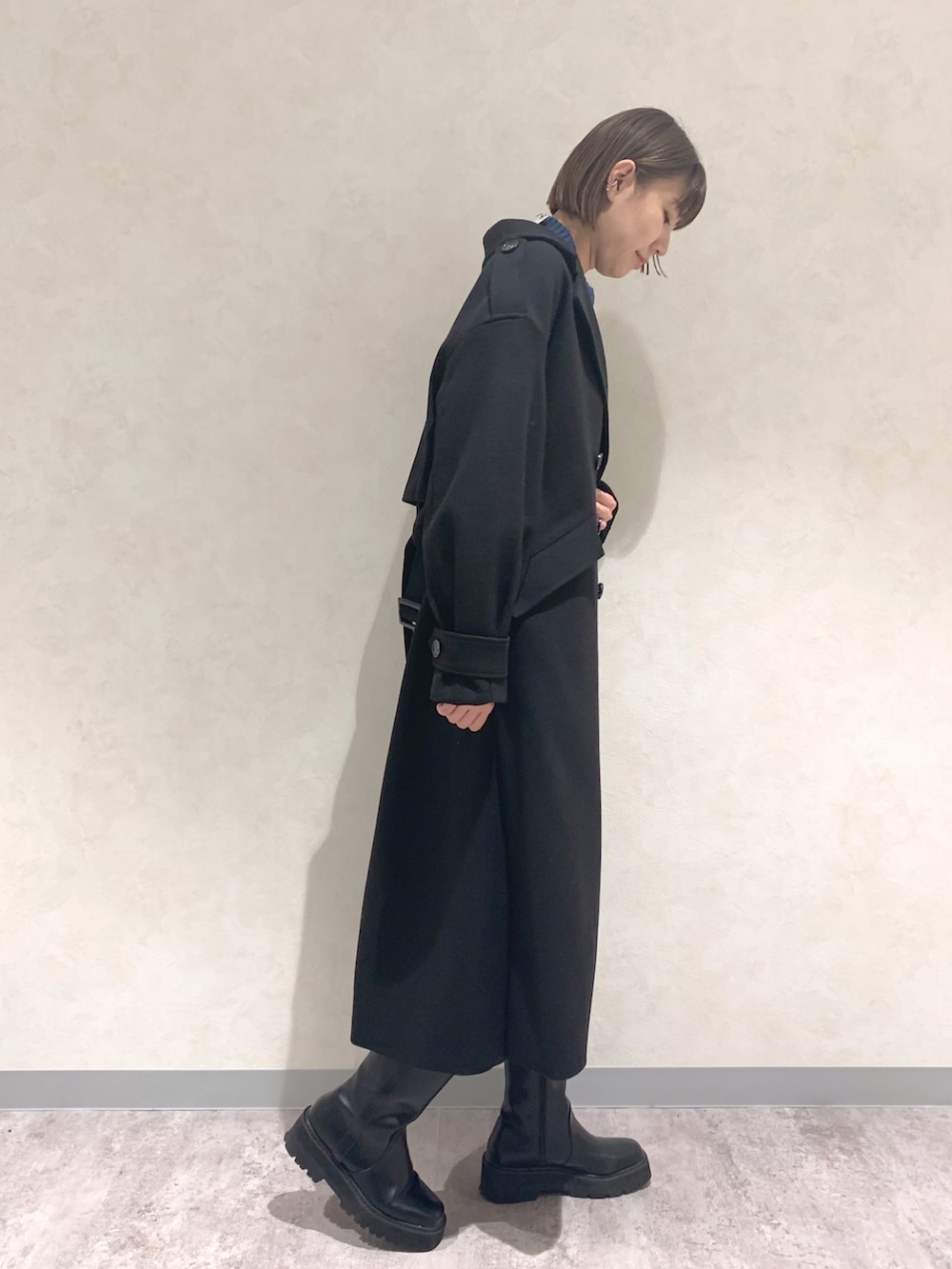 ブラック系のブーツ、ブラック系のその他パンツ、グリーン系のニット/セーターを着用したレディースの冬コーディネートの2枚目の写真