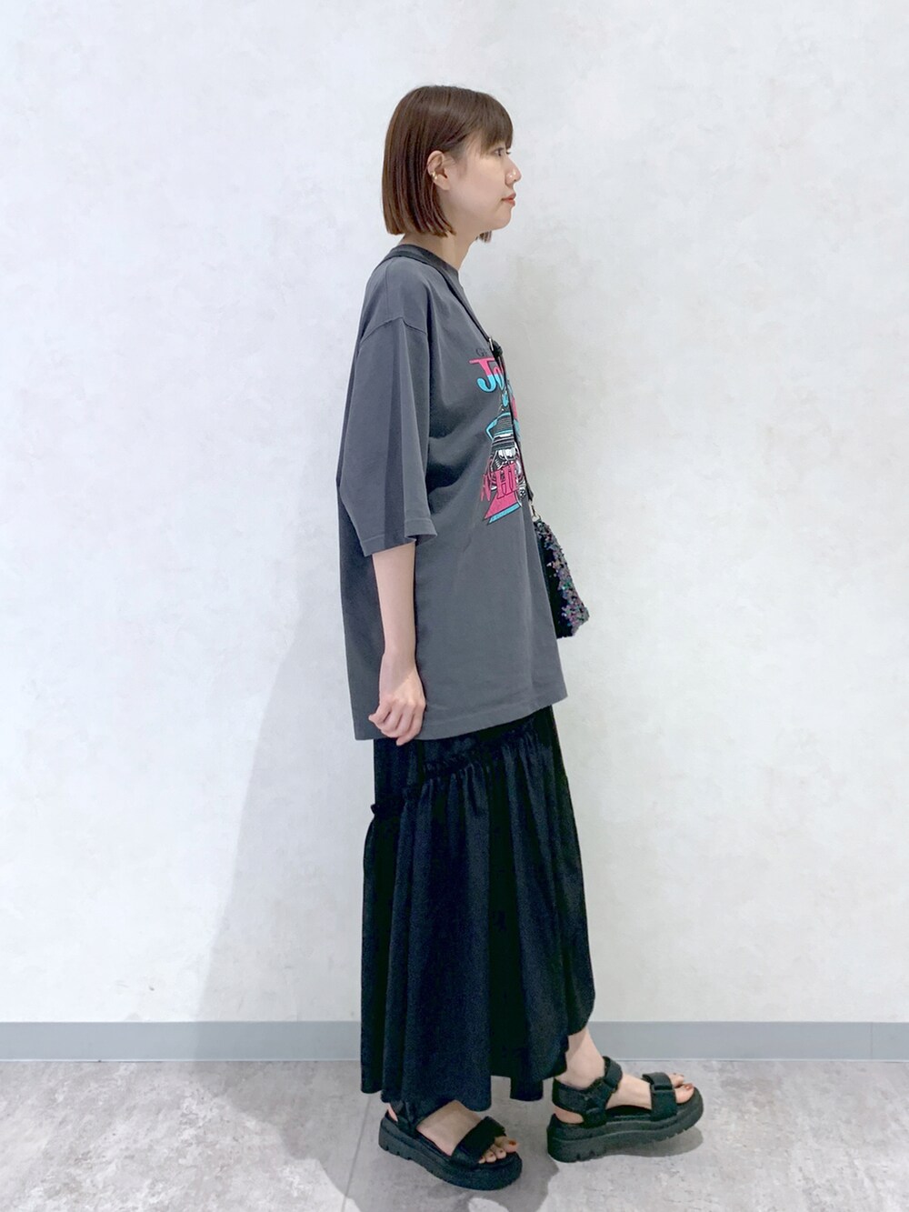 ブラック系のサンダル、ブラック系のスカート、ブラック系のショルダーバッグを着用したレディースの夏コーディネートの3枚目の写真