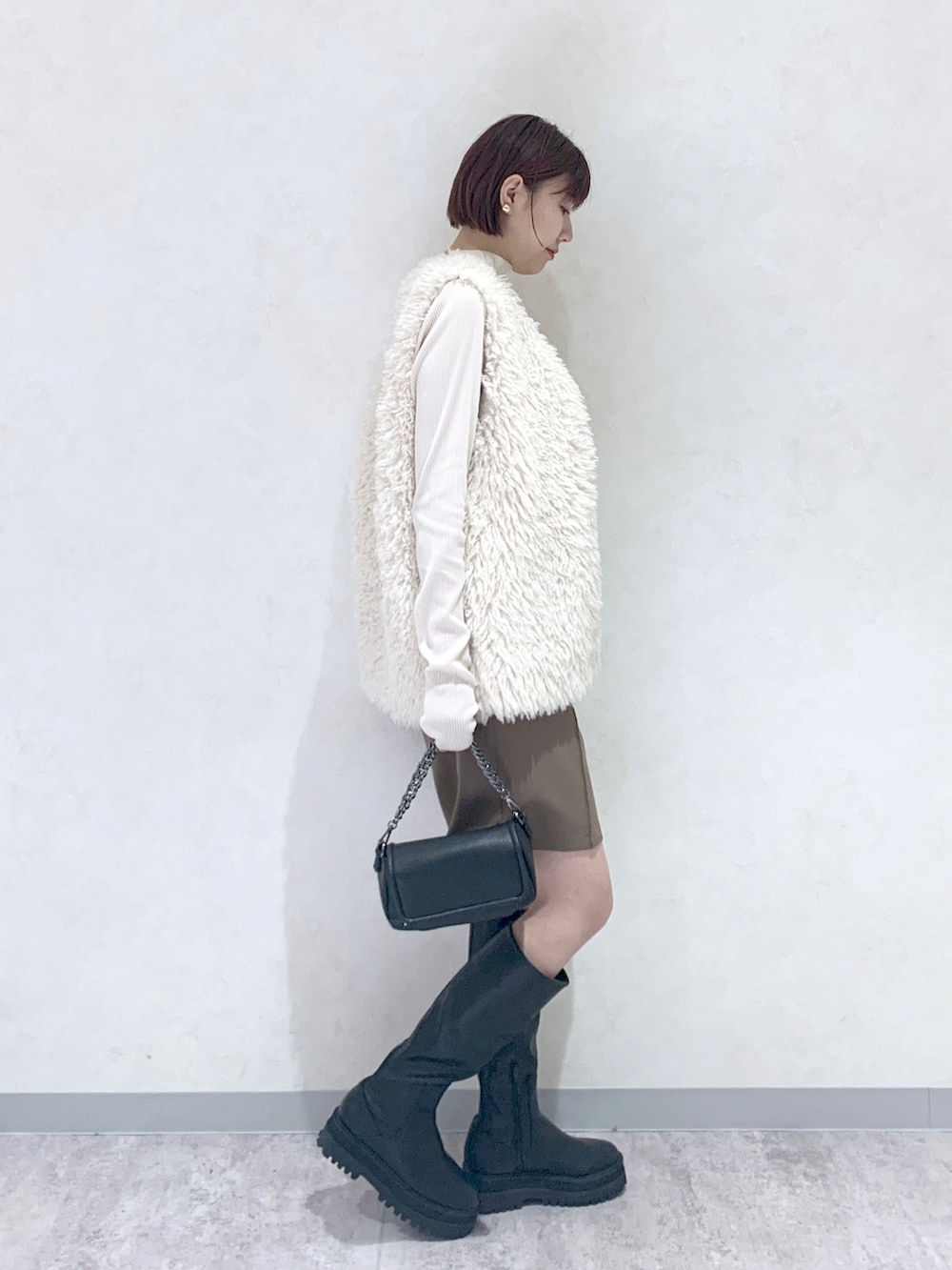 ブラック系のショルダーバッグ、ブラック系のブーツ、ブラウン系のその他パンツを着用したレディースの秋コーディネートの3枚目の写真