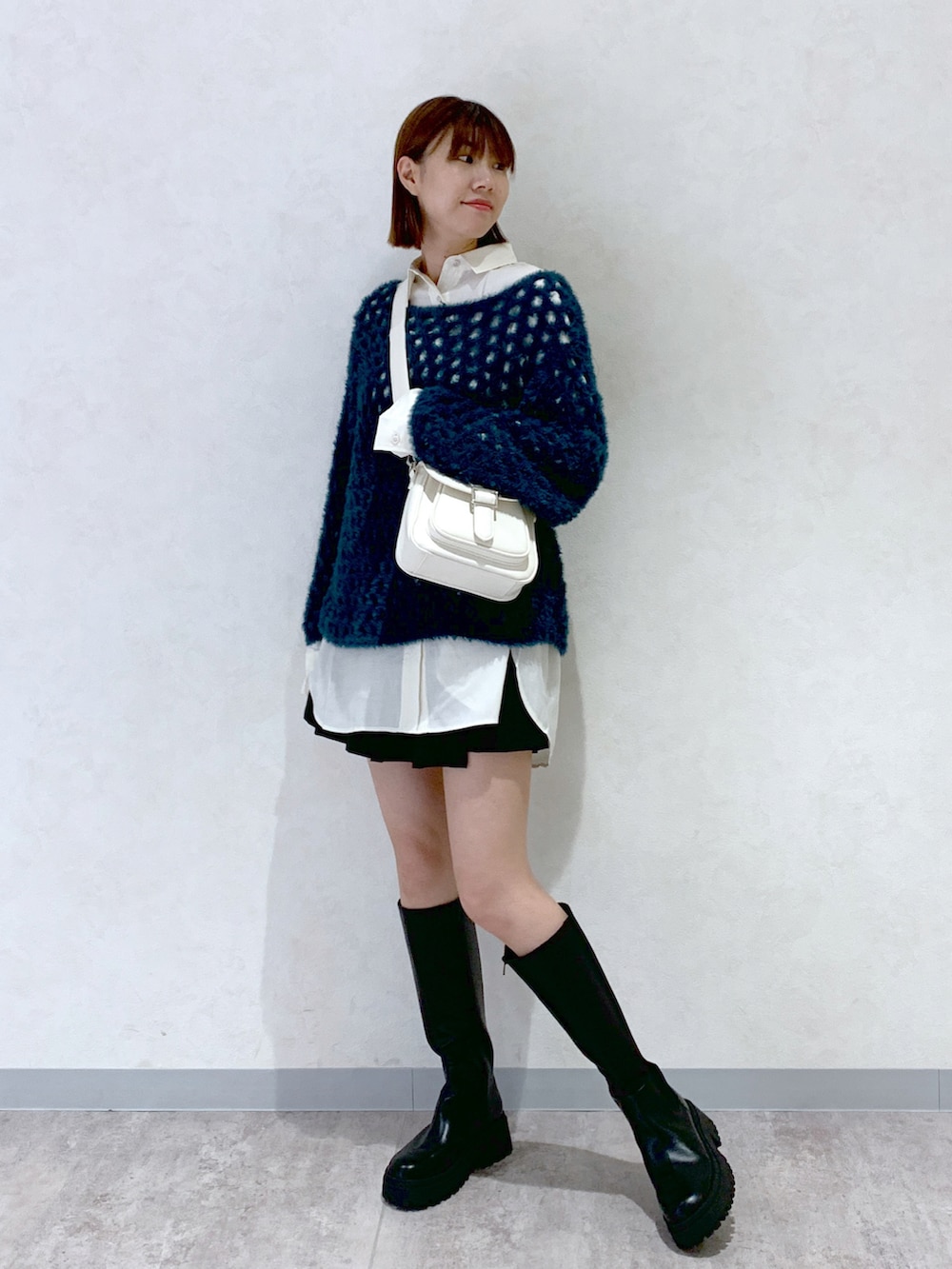 ブラック系のブーツ、ブラック系のパンツ、ホワイト系のシャツ/ブラウスを着用したレディースの秋コーディネートの3枚目の写真