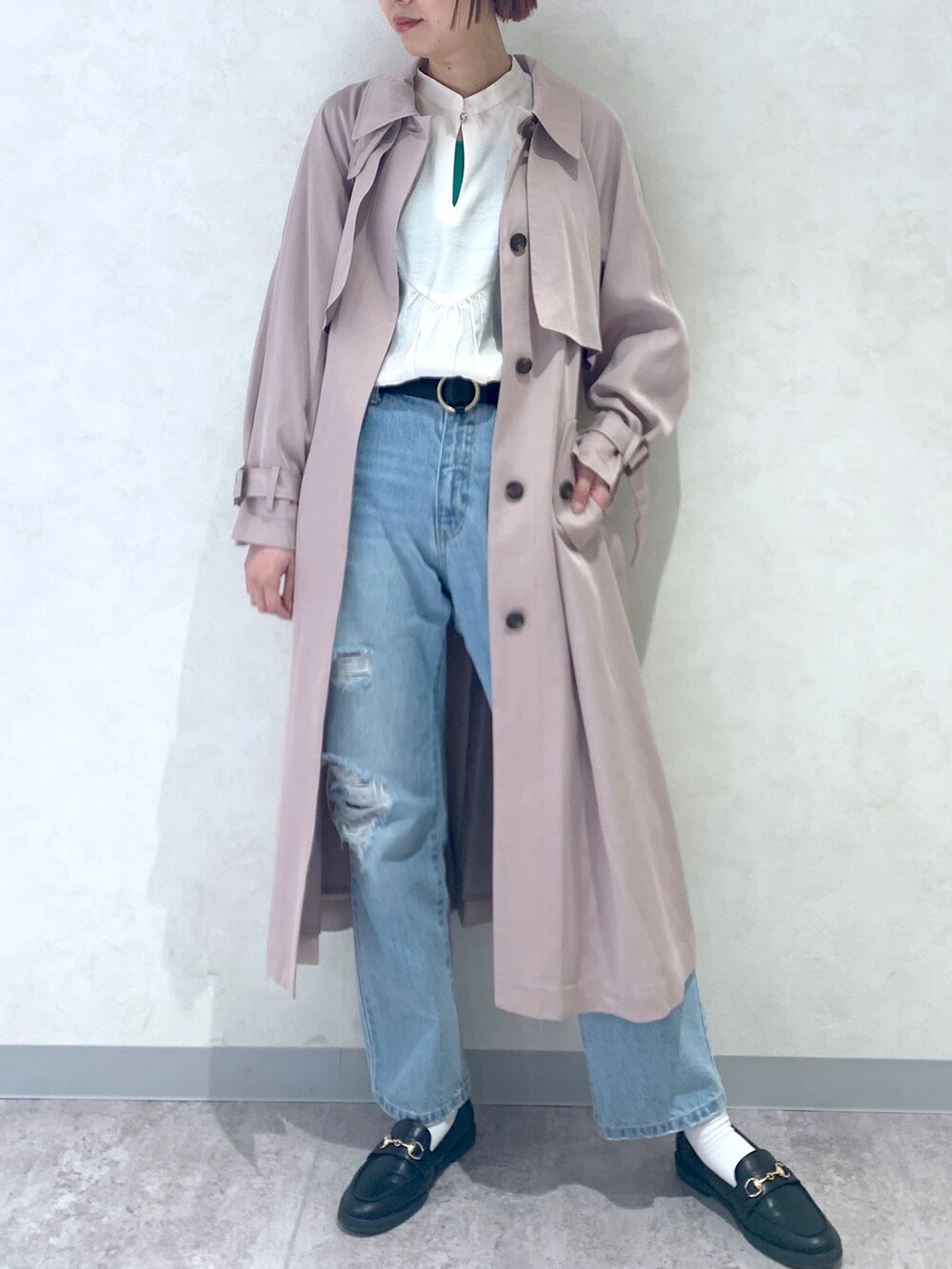 ブルー系のデニムパンツ、ベージュ系のトレンチコート、ブラック系のローファーを着用したレディースの春コーディネートの3枚目の写真