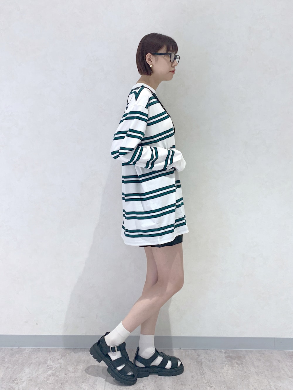 ブラック系のサンダル、ブラック系のショルダーバッグ、ホワイト系のTシャツ/カットソーを着用したレディースの夏コーディネートの3枚目の写真