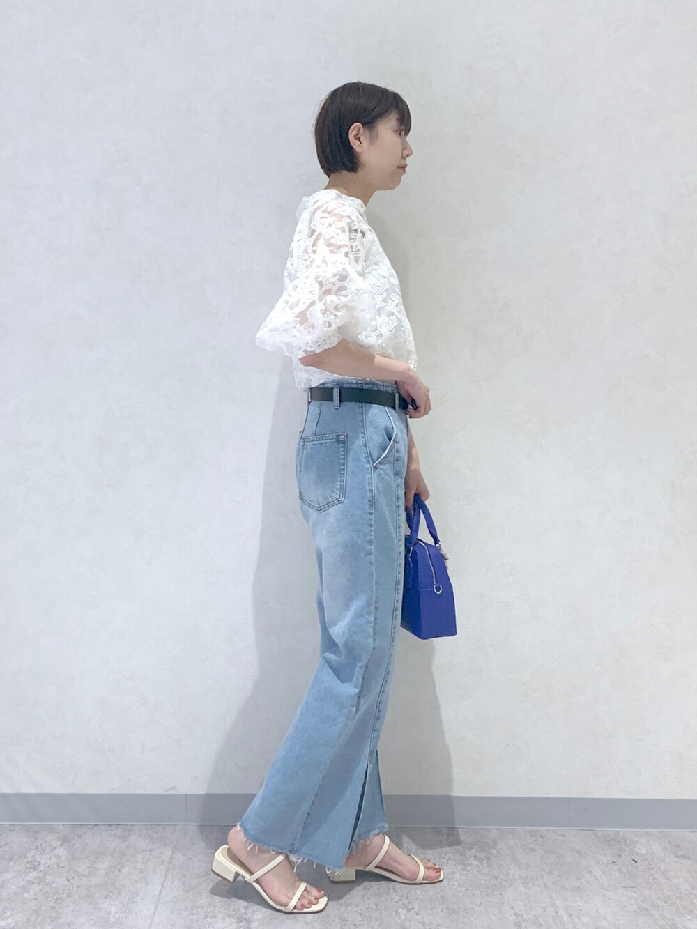 ブルー系のショルダーバッグ、ホワイト系のサンダル、ブルー系のデニムパンツを着用したレディースの夏コーディネートの3枚目の写真