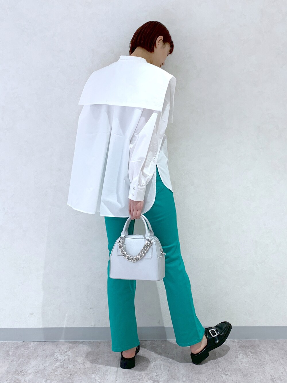 シルバー系のショルダーバッグ、ブラック系のローファー、グリーン系のデニムパンツを着用したレディースの春コーディネートの3枚目の写真