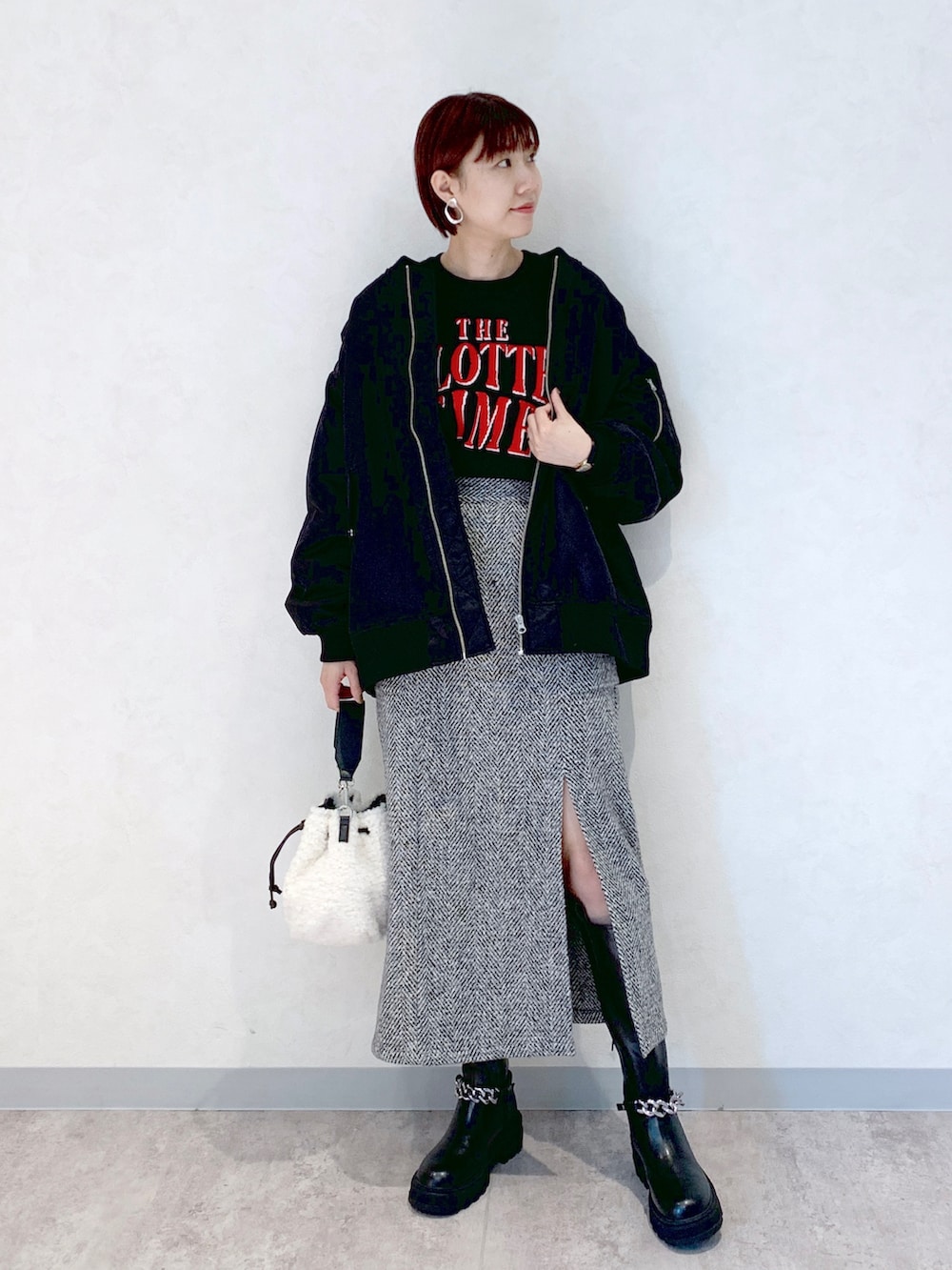 ホワイト系のショルダーバッグ、ブラック系のブーツ、ブラック系のスカートを着用したレディースの秋コーディネートの4枚目の写真