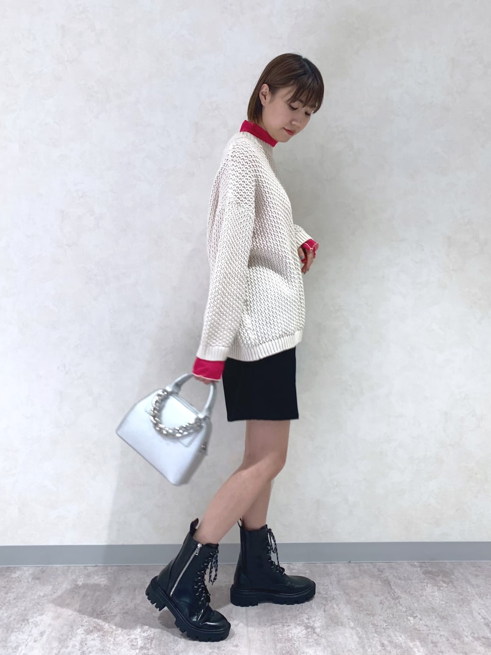 ホワイト系のニット/セーター、ブラック系のその他パンツ、ブラック系のブーツを着用したレディースの冬コーディネートの2枚目の写真