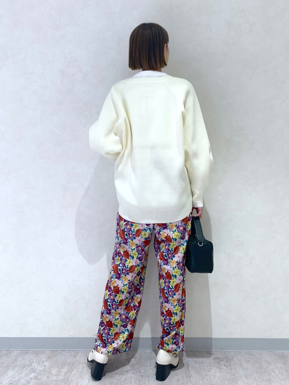 ホワイト系のその他パンツ、ホワイト系のパンプス、ブラック系のショルダーバッグを着用したレディースの冬コーディネートの4枚目の写真