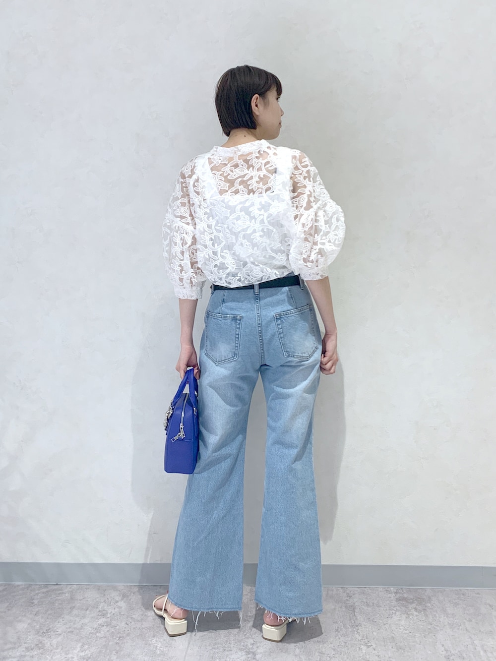 ブルー系のショルダーバッグ、ホワイト系のサンダル、ブルー系のデニムパンツを着用したレディースの夏コーディネートの4枚目の写真