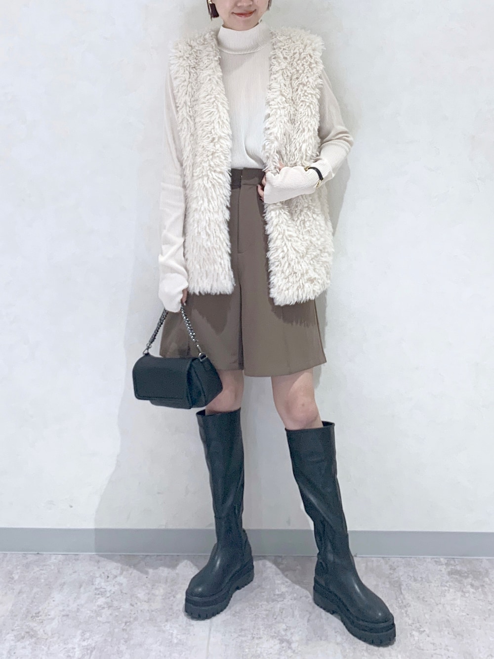 ブラック系のショルダーバッグ、ブラック系のブーツ、ブラウン系のその他パンツを着用したレディースの秋コーディネートの2枚目の写真