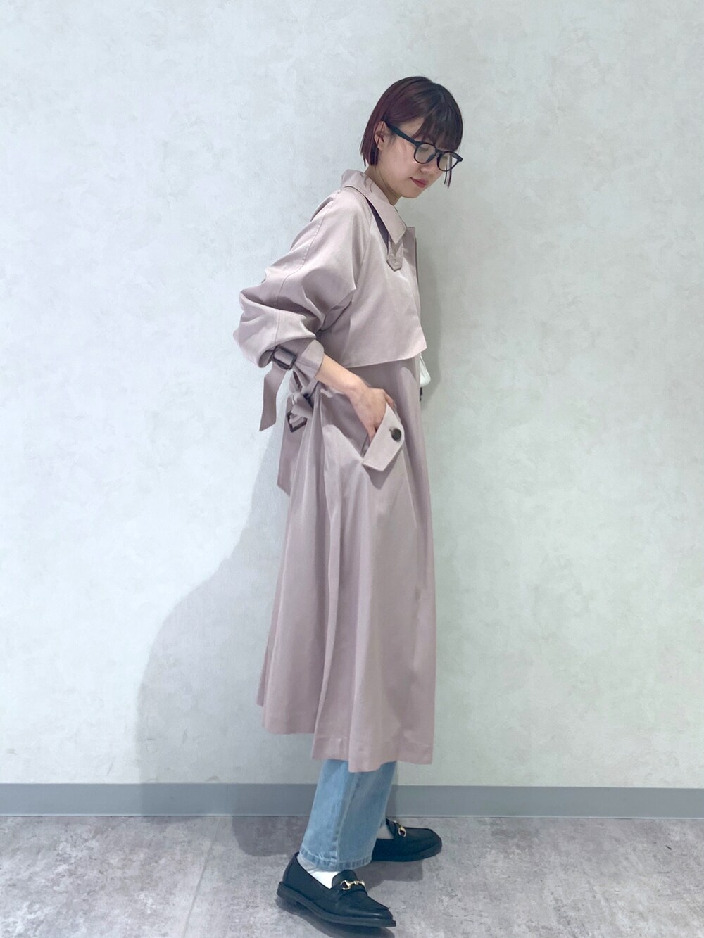 ブルー系のデニムパンツ、ベージュ系のトレンチコート、ブラック系のローファーを着用したレディースの春コーディネートの2枚目の写真