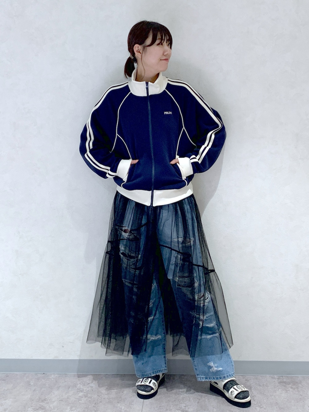 ブルー系のセットアップ、ブルー系のデニムパンツ、ブラック系のワンピースを着用したレディースの春コーディネートの2枚目の写真