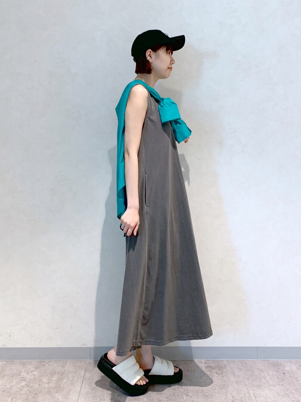 グレー系のワンピース、ホワイト系のサンダル、グリーン系のシャツ/ブラウスを着用したレディースの春コーディネートの3枚目の写真