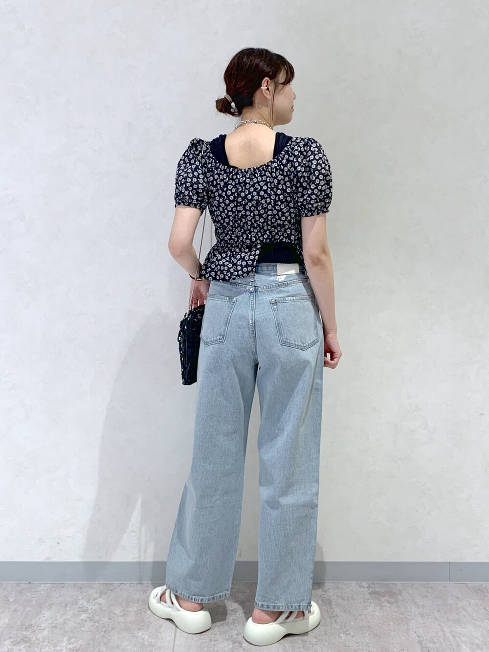 ブルー系のデニムパンツ、ホワイト系のサンダル、ブラック系のシャツ/ブラウスを着用したレディースの春コーディネートの4枚目の写真