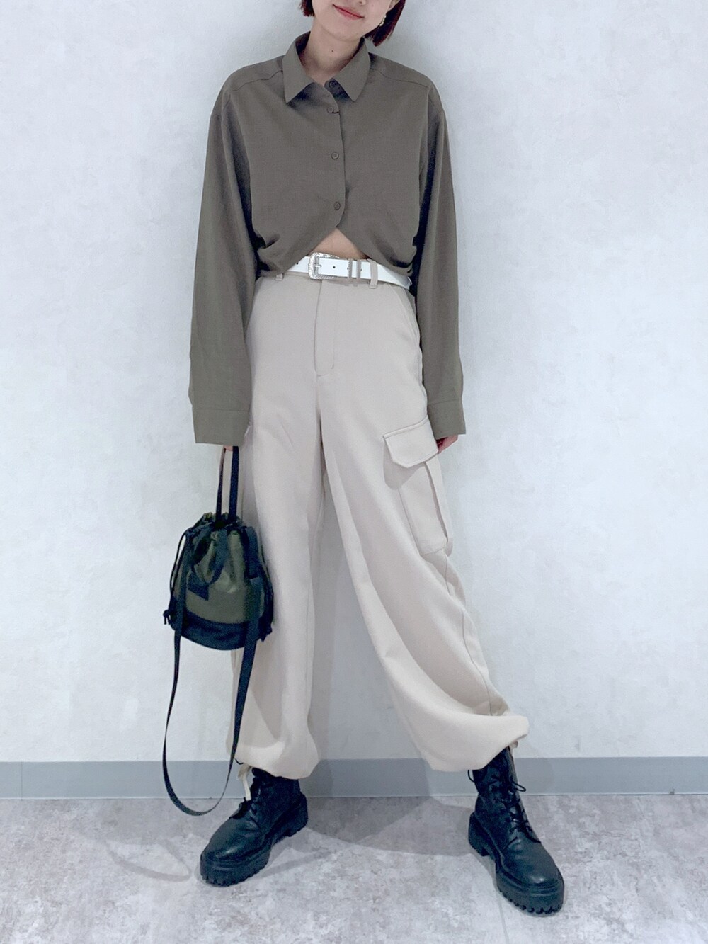 ブラウン系のシャツ/ブラウス、ベージュ系のパンツ、ブラック系のブーツを着用したレディースの秋コーディネートの2枚目の写真