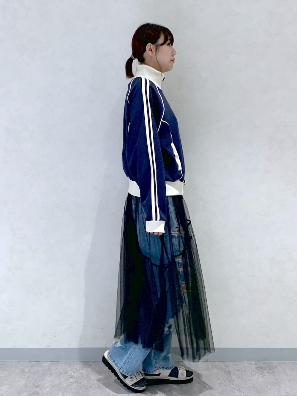 ブルー系のセットアップ、ブルー系のデニムパンツ、ブラック系のワンピースを着用したレディースの春コーディネートの3枚目の写真