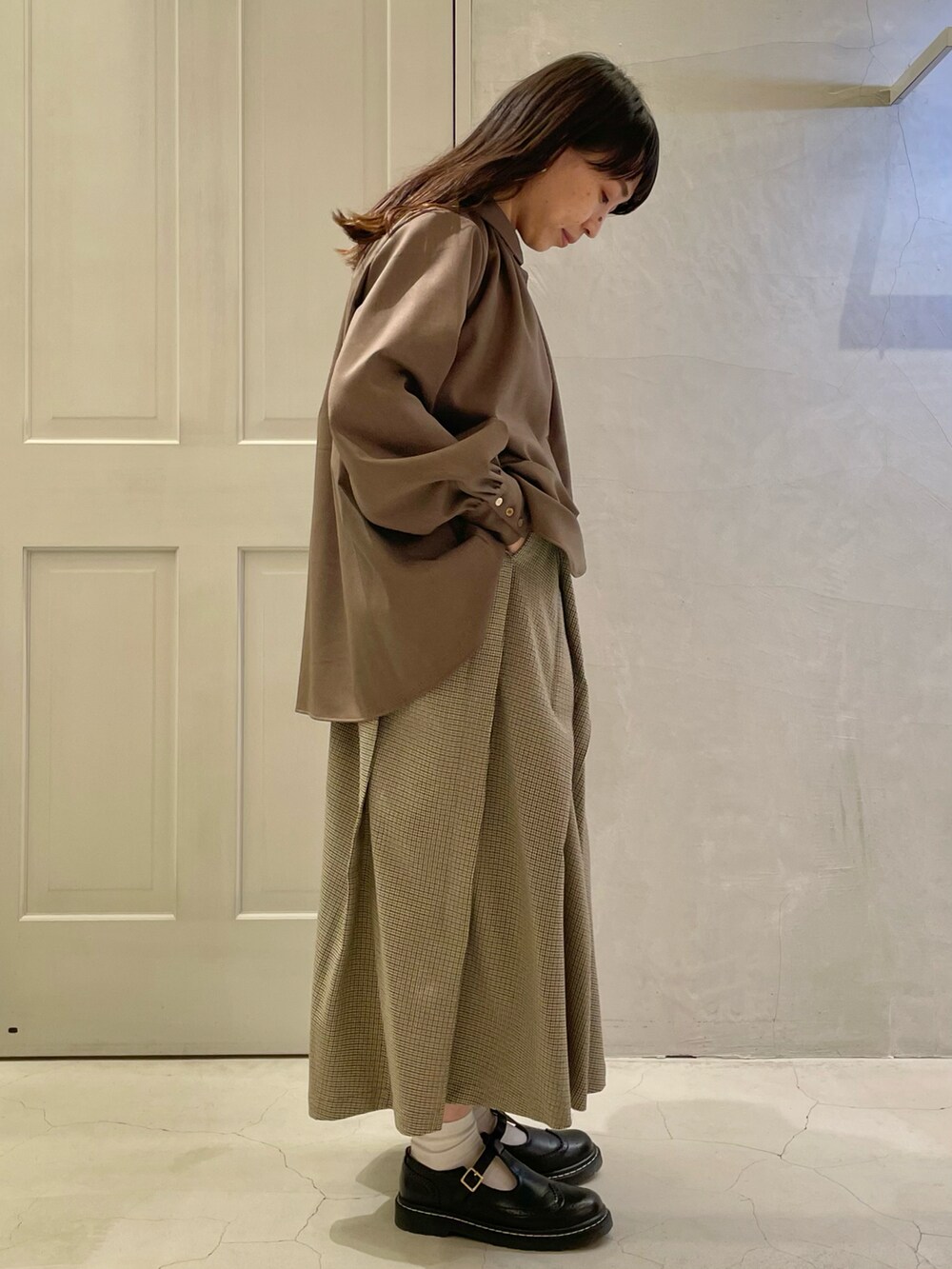 ブラウン系のシャツ/ブラウス、ブラック系のその他シューズ、ベージュ系のスカートを着用したレディースの秋コーディネートの4枚目の写真