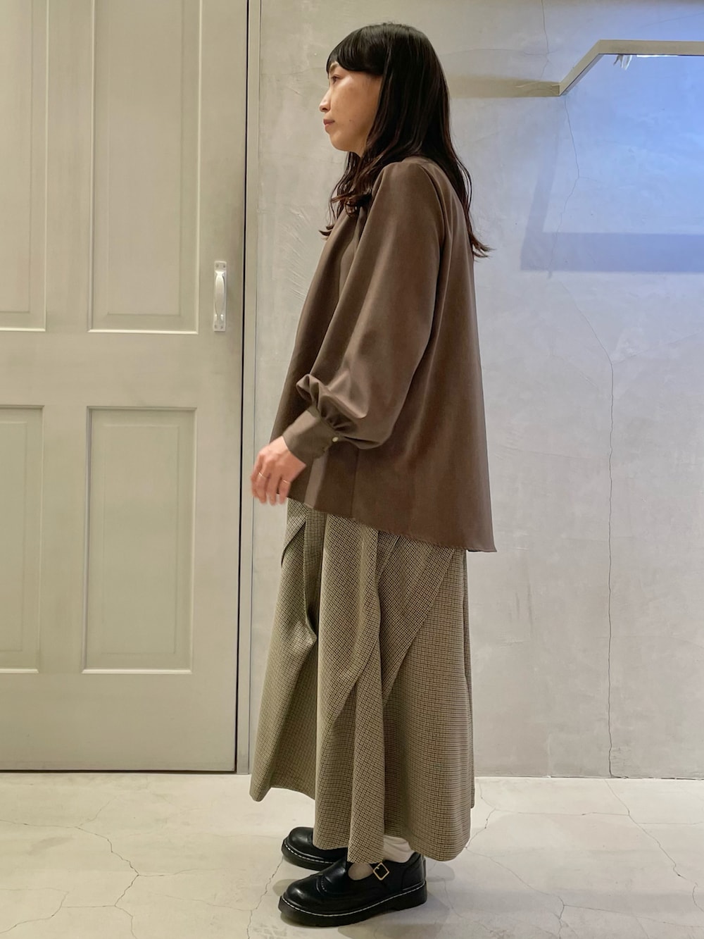 ブラウン系のシャツ/ブラウス、ブラック系のその他シューズ、ベージュ系のスカートを着用したレディースの秋コーディネートの2枚目の写真