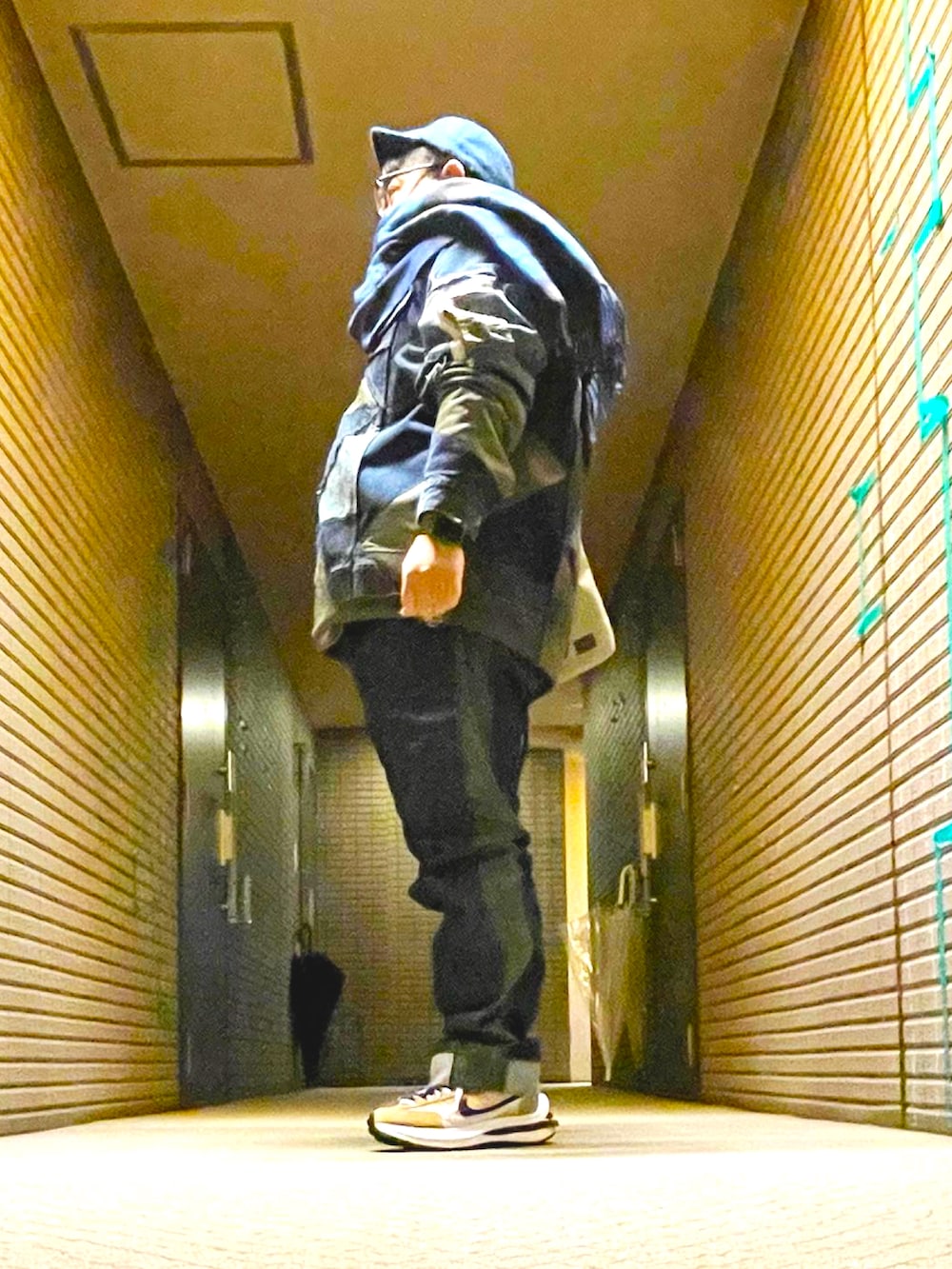 その他のミリタリージャケット、ブルー系のデニムパンツ、ベージュ系のスニーカーを着用したメンズの冬コーディネートの3枚目の写真