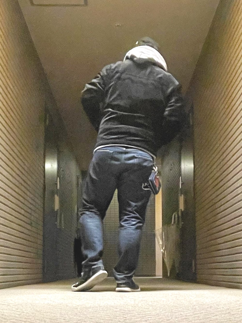 グレー系のパーカー、ブラック系のライダースジャケット、ブルー系のデニムパンツを着用したメンズの冬コーディネートの4枚目の写真