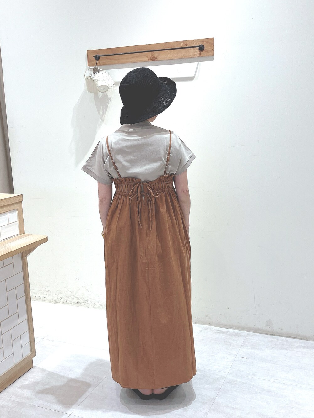 ベージュ系のTシャツ/カットソー、オレンジ系のワンピース、ブラック系のサンダルを着用したレディースの春コーディネートの3枚目の写真