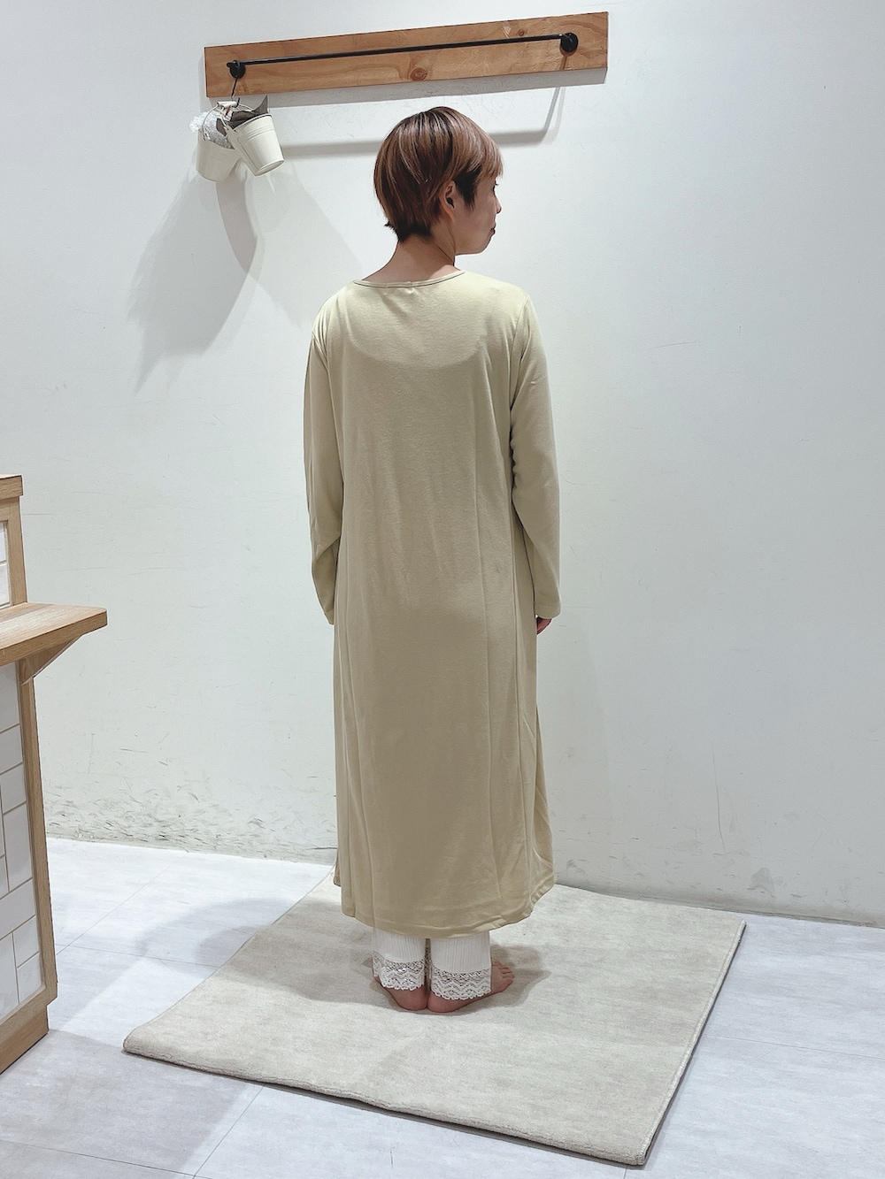 イエロー系のワンピース、ホワイト系のパンツを着用したレディースの秋コーディネートの3枚目の写真