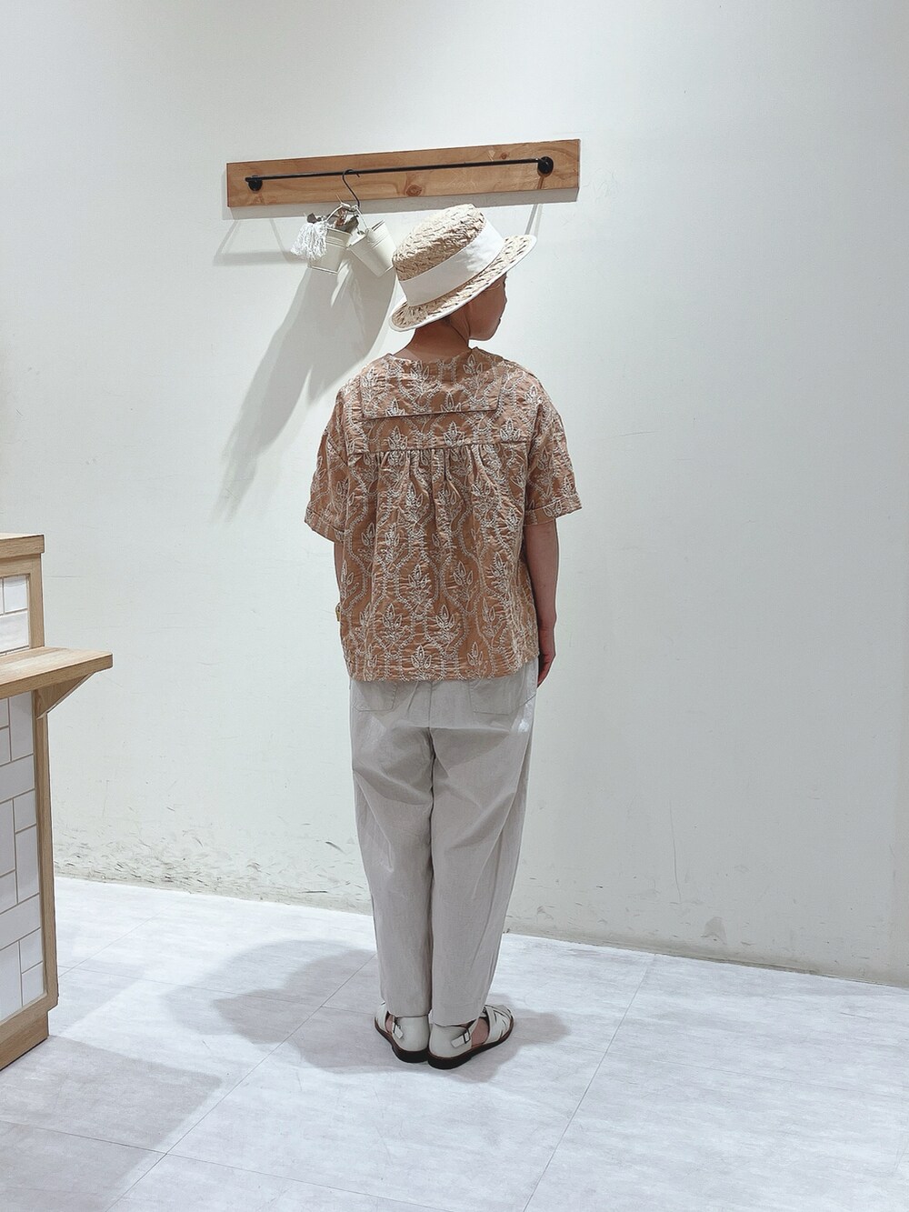 オレンジ系のシャツ/ブラウス、ホワイト系のその他パンツ、ホワイト系のサンダルを着用したレディースの春コーディネートの3枚目の写真