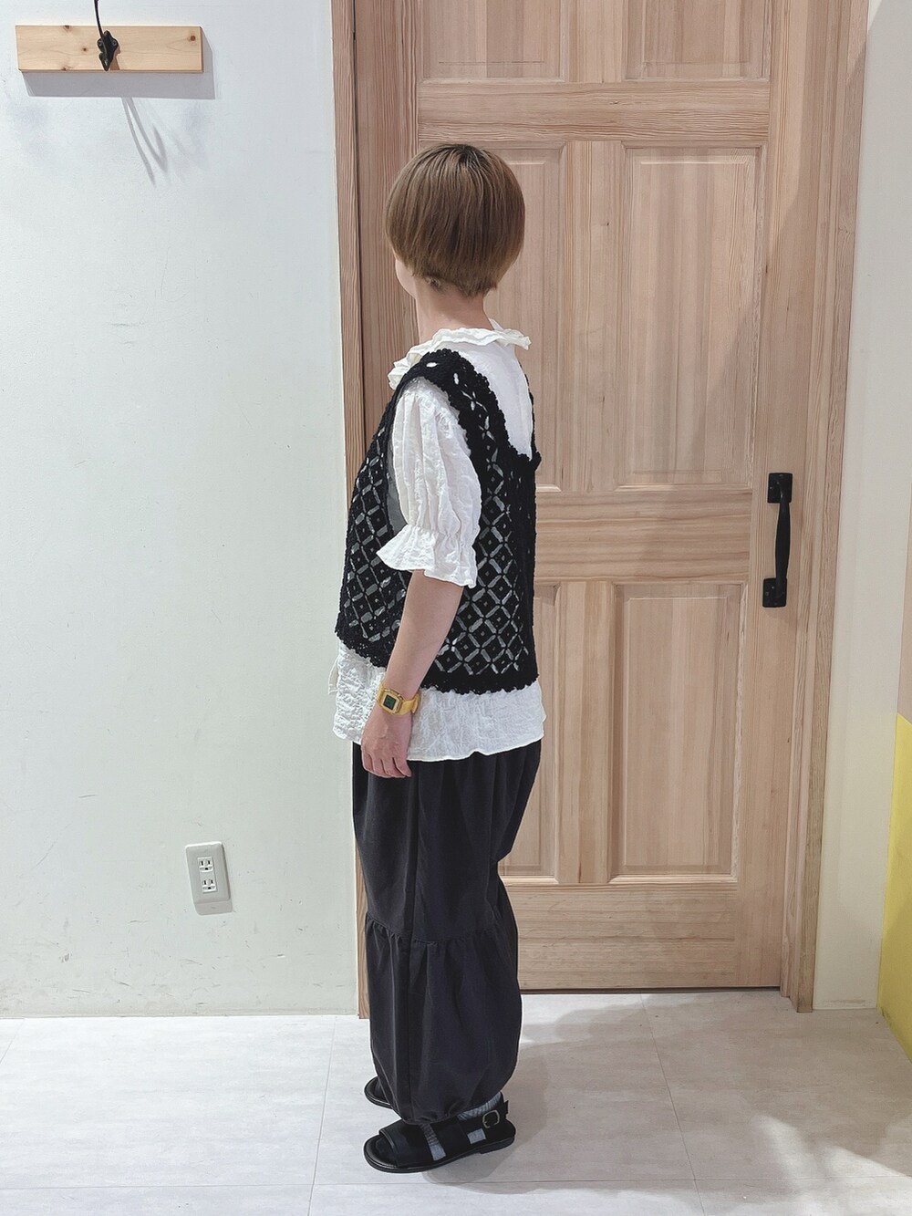 ブラック系のベスト、ホワイト系のシャツ/ブラウス、ブラック系のパンツを着用したレディースの夏コーディネートの2枚目の写真