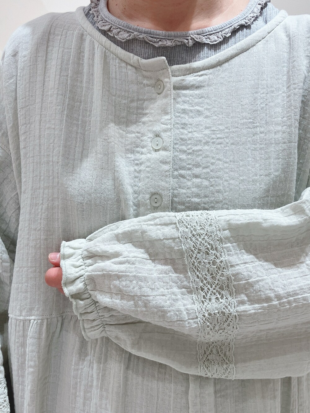 グリーン系のワンピース、グレー系のTシャツ/カットソー、グレー系のパンツを着用したレディースの冬コーディネートの4枚目の写真