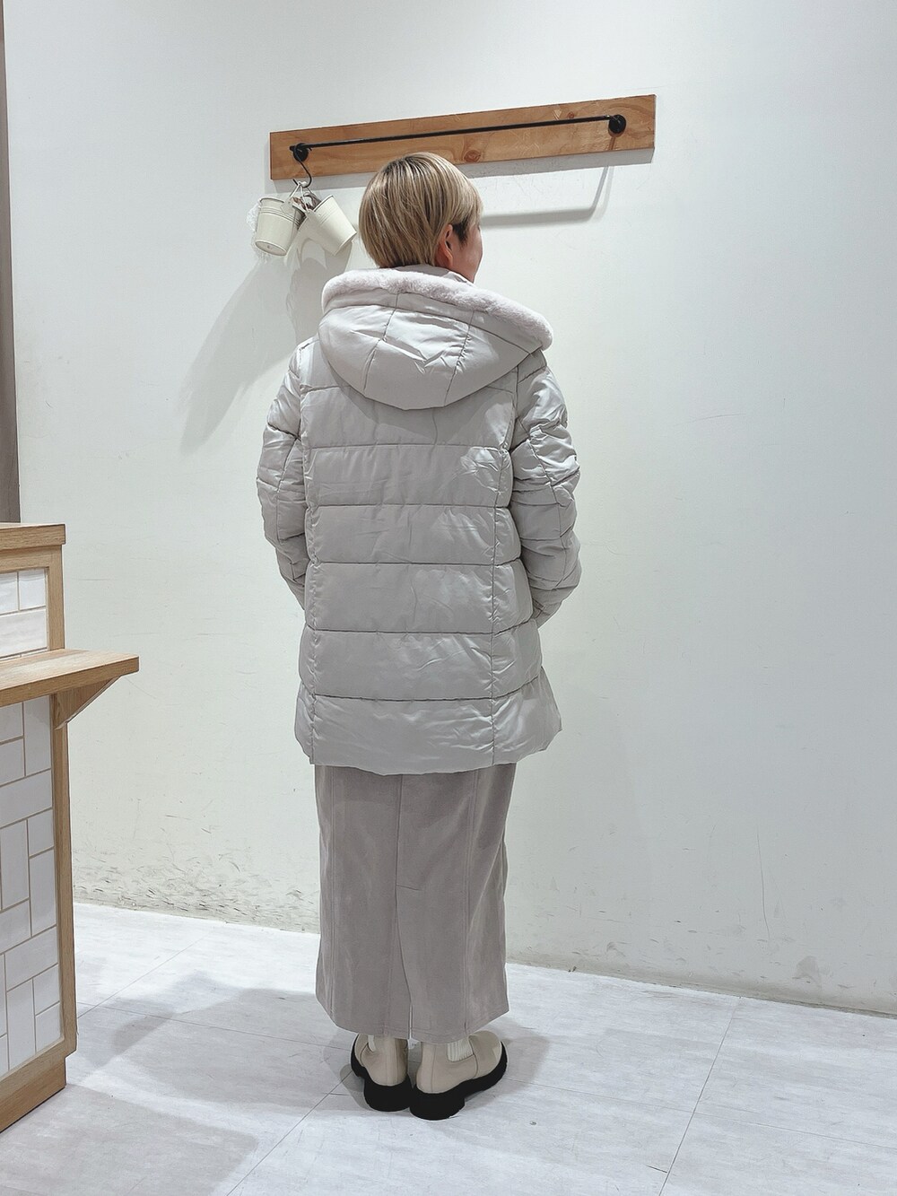 ベージュ系のその他アウター、グリーン系のニット/セーター、ベージュ系のスカートを着用したレディースの秋コーディネートの3枚目の写真