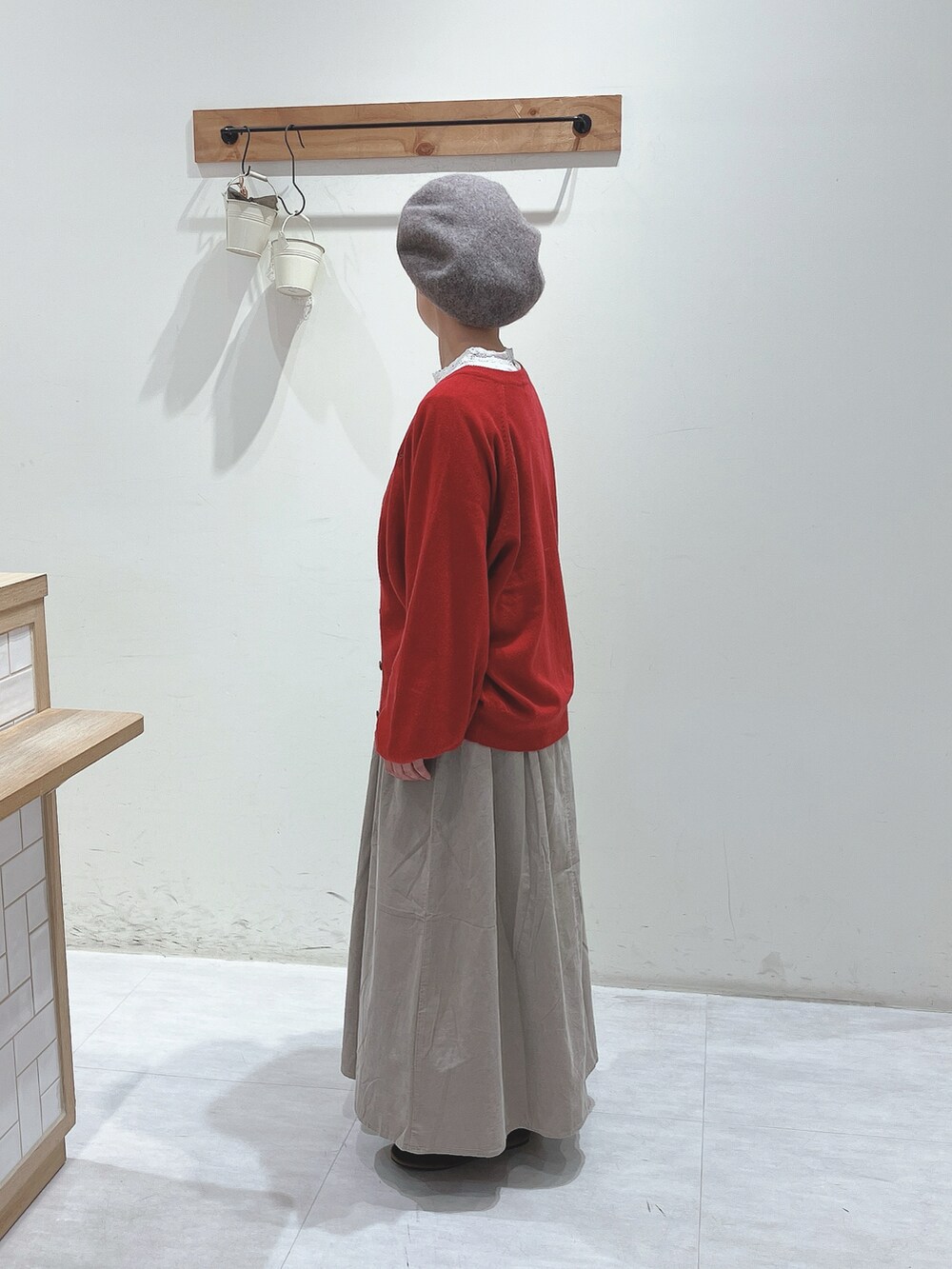 ホワイト系のTシャツ/カットソー、レッド系のカーディガン/ボレロ、ベージュ系のスカートを着用したレディースの秋コーディネートの2枚目の写真