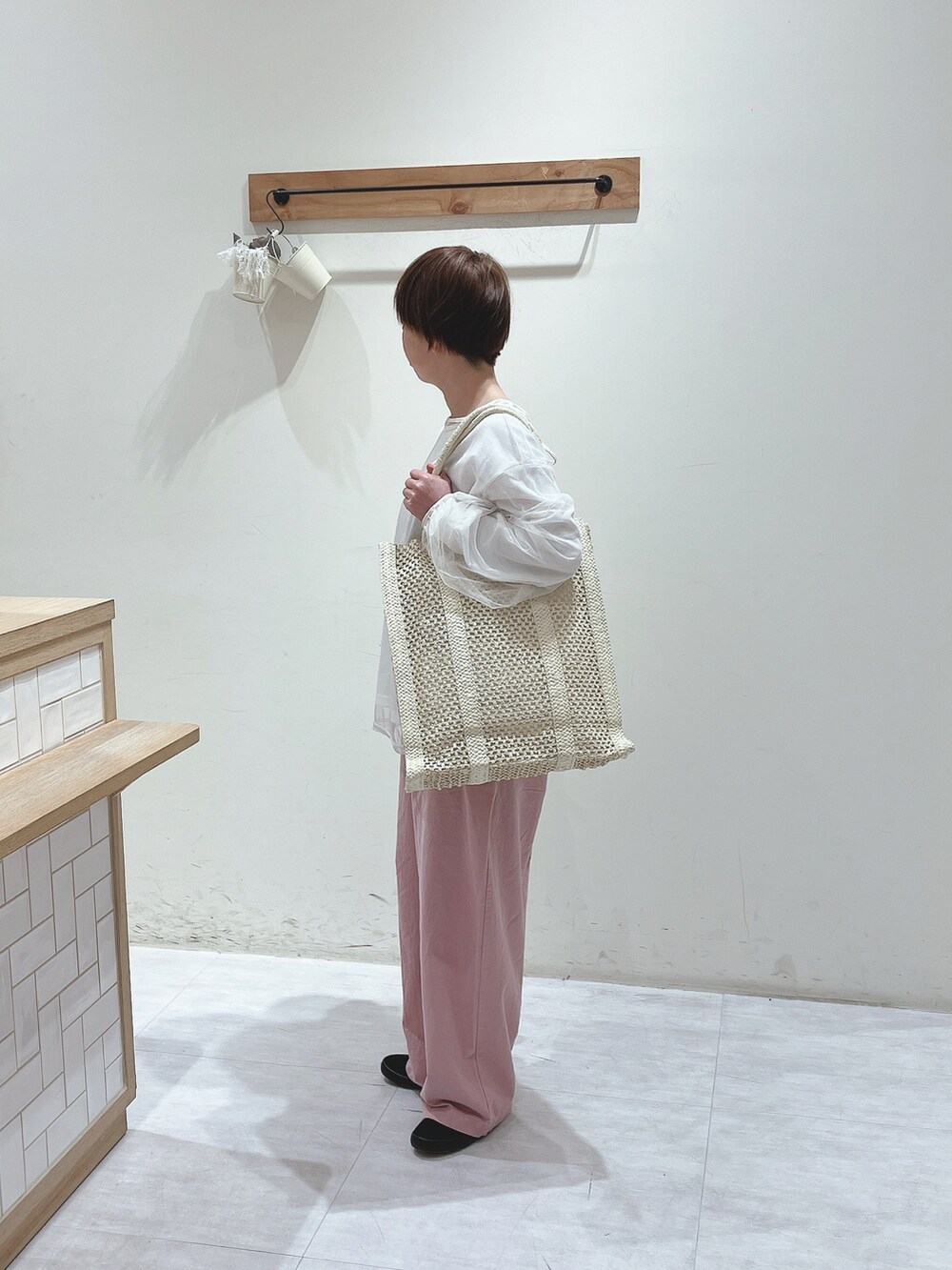 ホワイト系のTシャツ/カットソー、ホワイト系のハンドバッグ、ピンク系のパンツを着用したレディースの春コーディネートの2枚目の写真