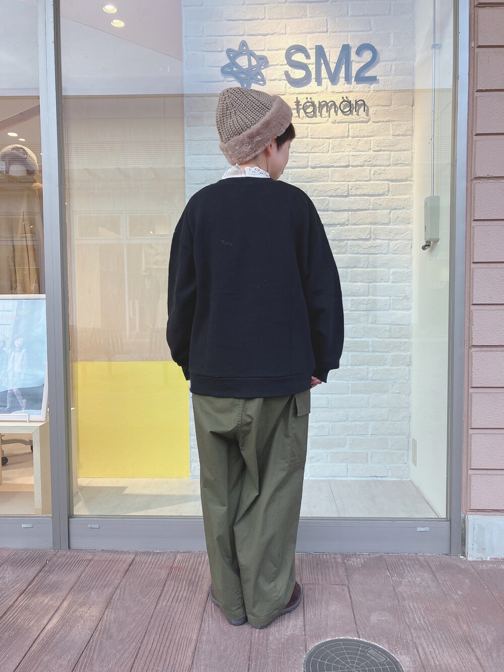 ブラック系のスウェット、グリーン系のカーゴパンツ、ベージュ系のTシャツ/カットソーを着用したレディースの秋コーディネートの3枚目の写真