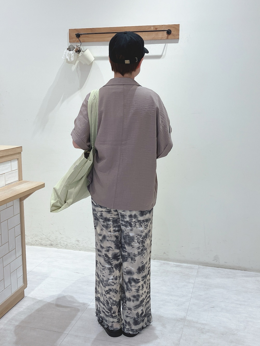 ブラウン系のシャツ/ブラウス、グリーン系のハンドバッグ、ホワイト系のTシャツ/カットソーを着用したレディースの春コーディネートの3枚目の写真