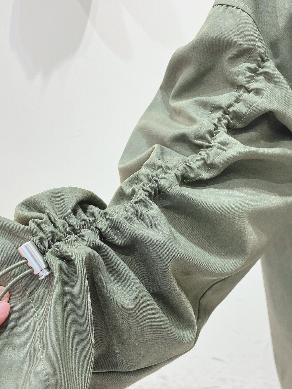 グリーン系のその他アウター、グリーン系のTシャツ/カットソー、ブルー系のデニムパンツを着用したレディースの冬コーディネートの4枚目の写真