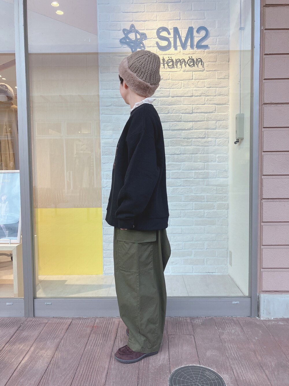 ブラック系のスウェット、グリーン系のカーゴパンツ、ベージュ系のTシャツ/カットソーを着用したレディースの秋コーディネートの2枚目の写真