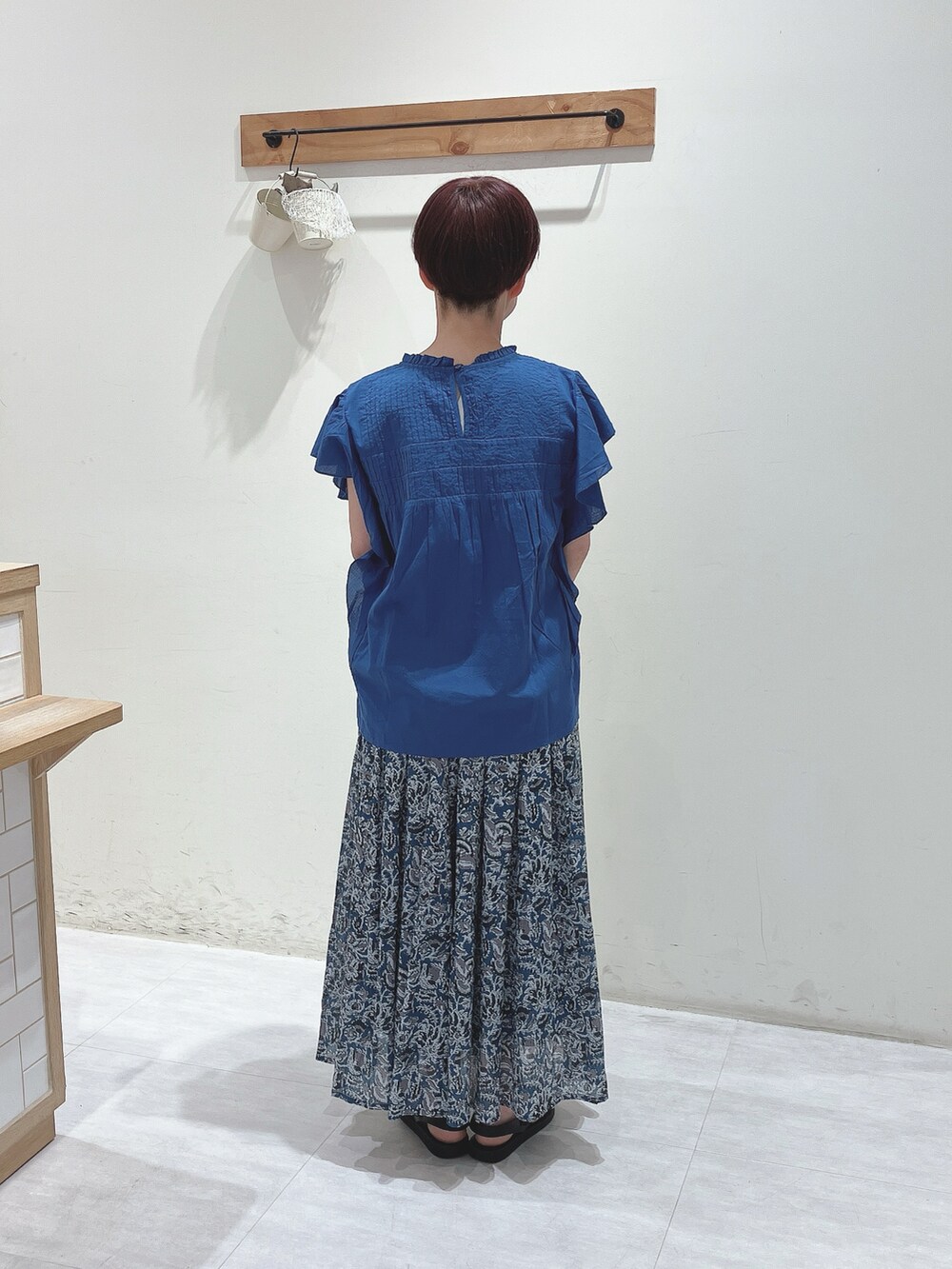 ホワイト系のハンドバッグ、ブルー系のシャツ/ブラウス、ブルー系のスカートを着用したレディースの夏コーディネートの3枚目の写真