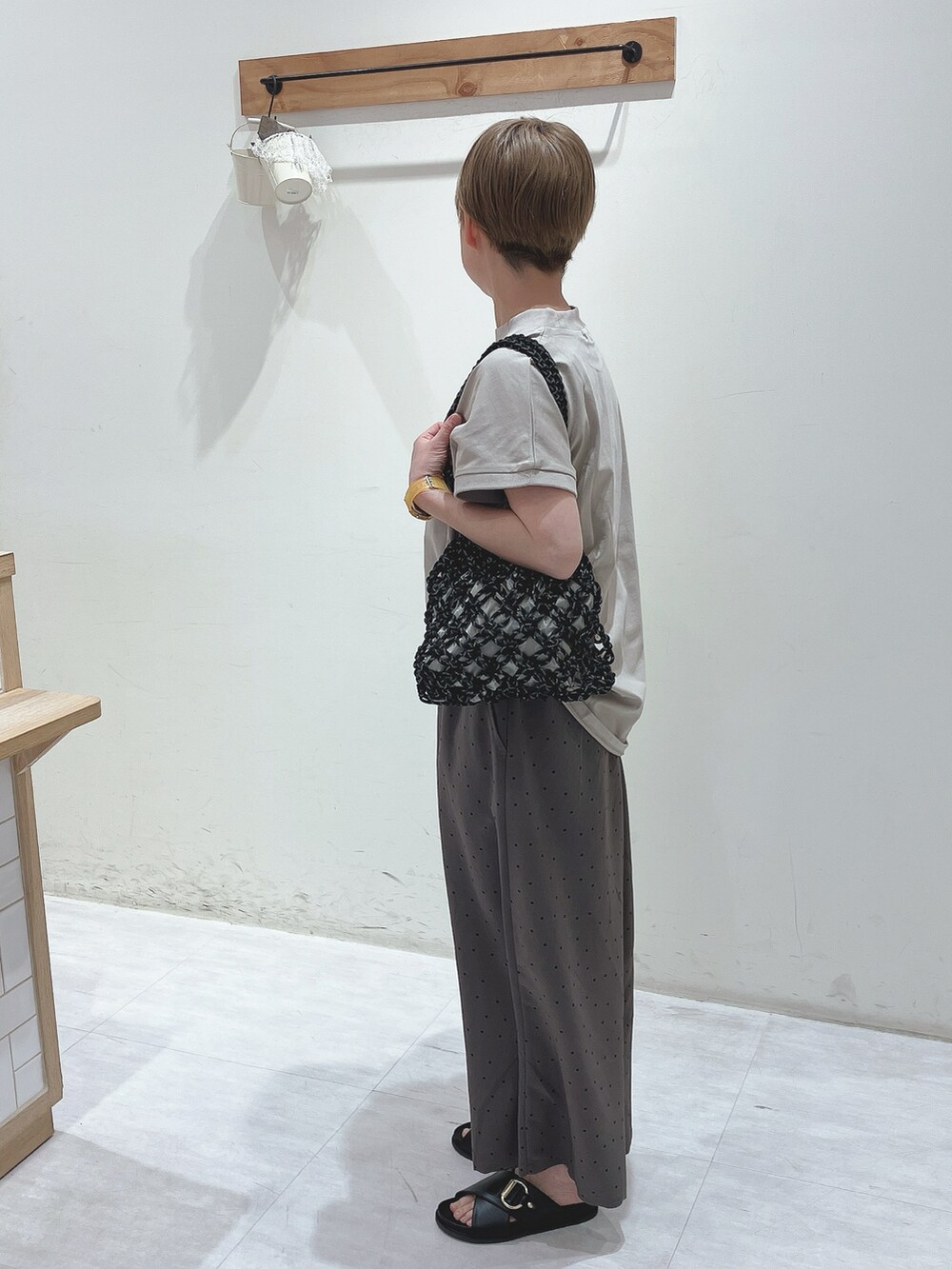 ベージュ系のTシャツ/カットソー、ブラック系のハンドバッグ、グレー系のその他パンツを着用したレディースの春コーディネートの2枚目の写真