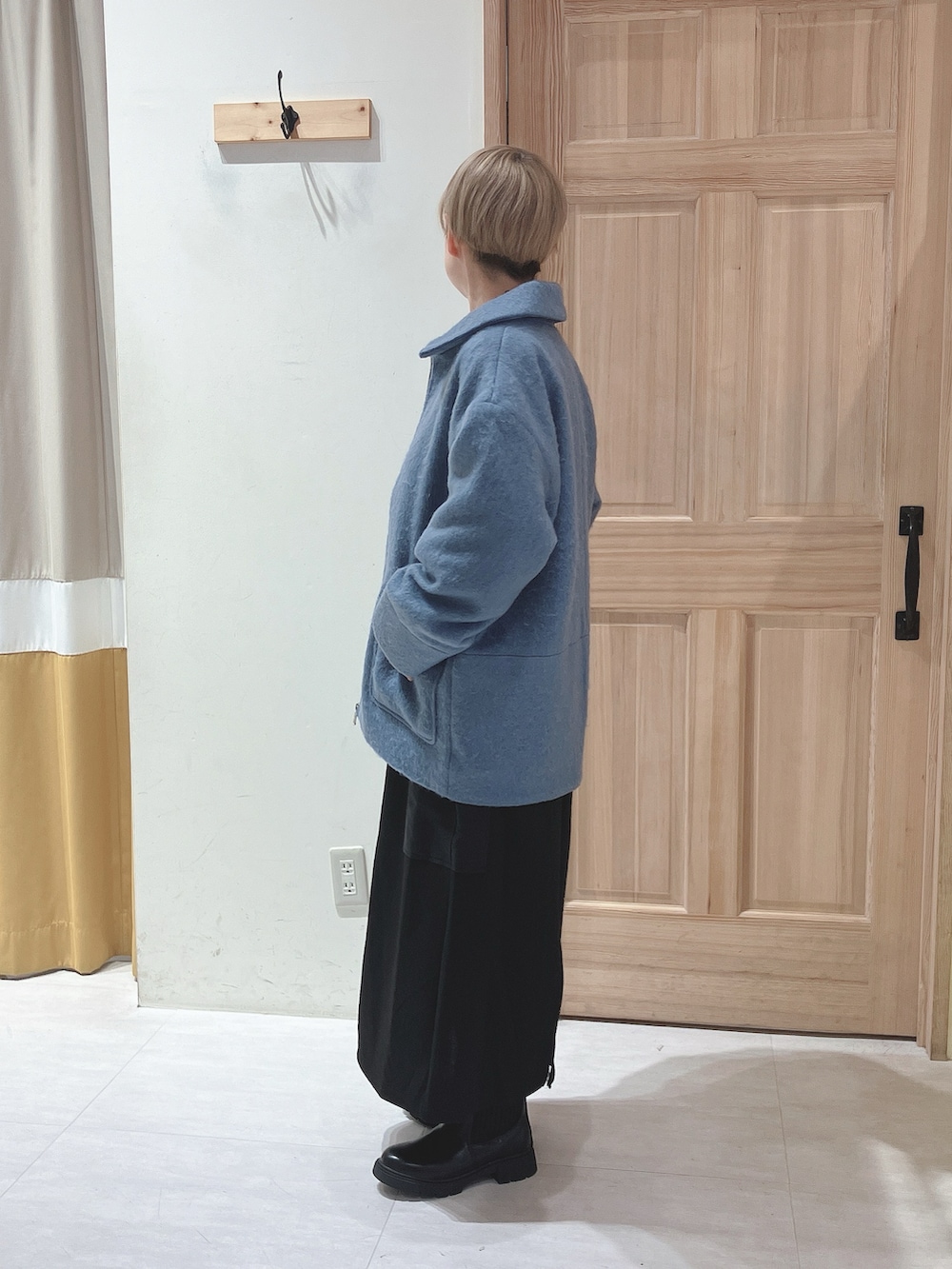 ブルー系のノーカラージャケット、グレー系のTシャツ/カットソー、ブラック系のスカートを着用したレディースの秋コーディネートの2枚目の写真