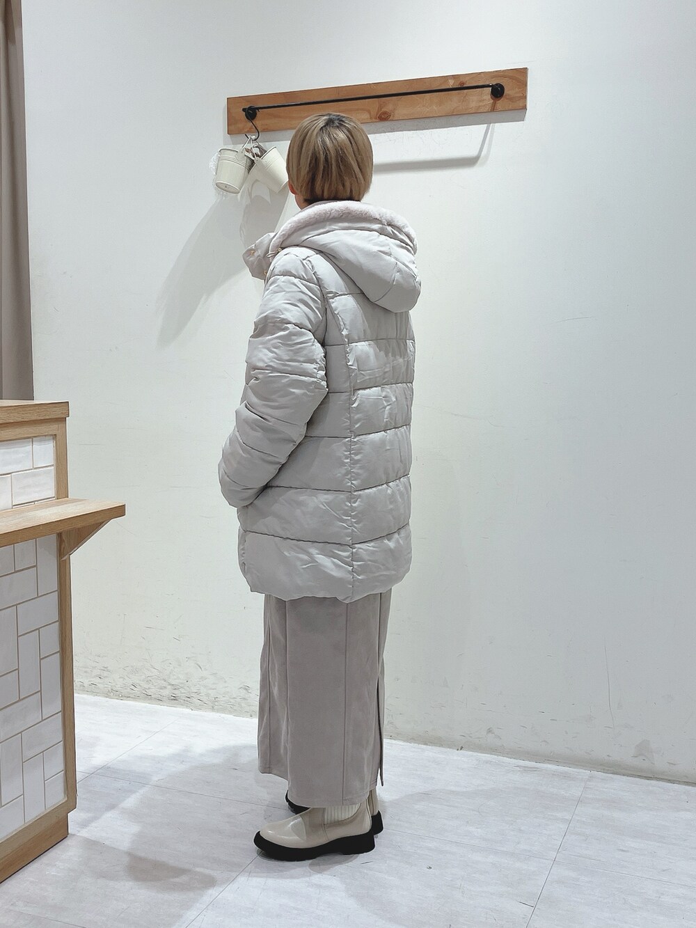 ベージュ系のその他アウター、グリーン系のニット/セーター、ベージュ系のスカートを着用したレディースの秋コーディネートの2枚目の写真