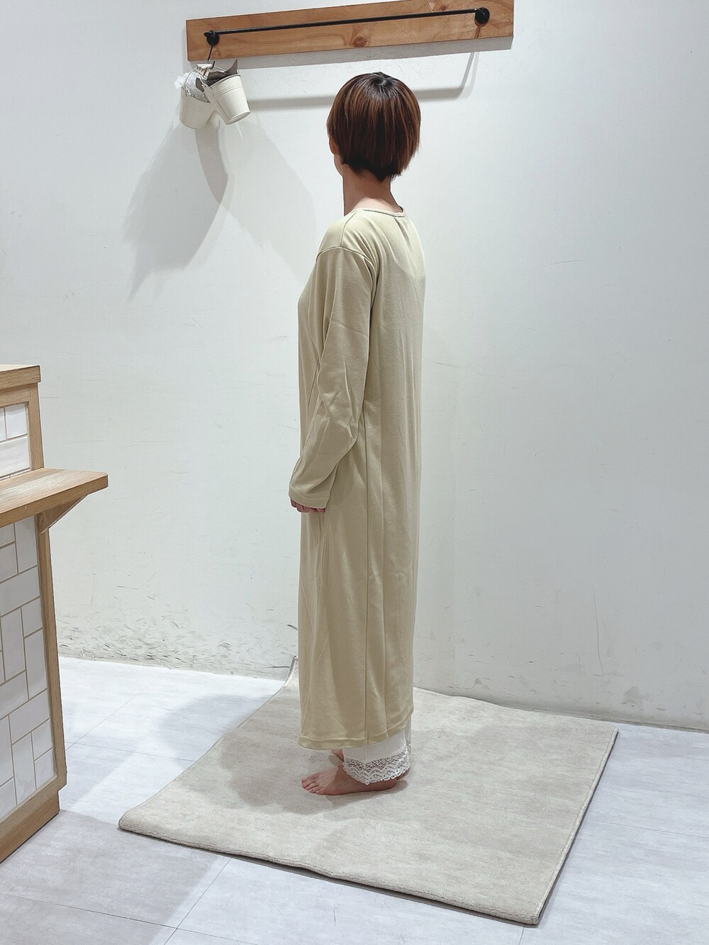 イエロー系のワンピース、ホワイト系のパンツを着用したレディースの秋コーディネートの2枚目の写真