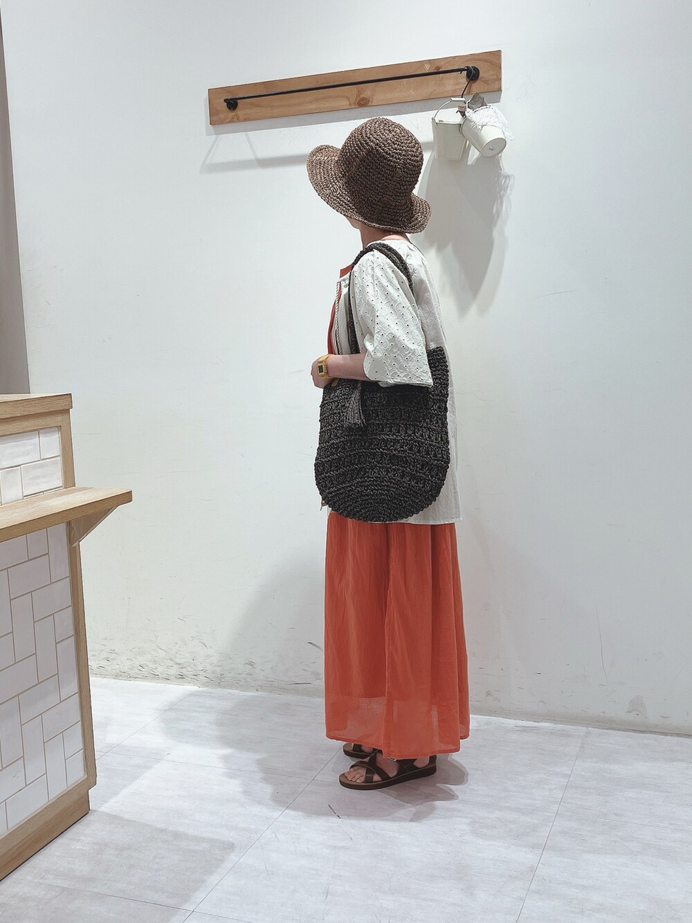 ベージュ系のシャツ/ブラウス、レッド系のワンピース、ブラウン系のハンドバッグを着用したレディースの春コーディネートの2枚目の写真